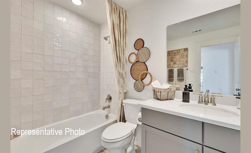 Bathroom featuring a white subway-tiled shower, a soaking tub, a single vanity with a white countertop, and a large wall-mounted mirror