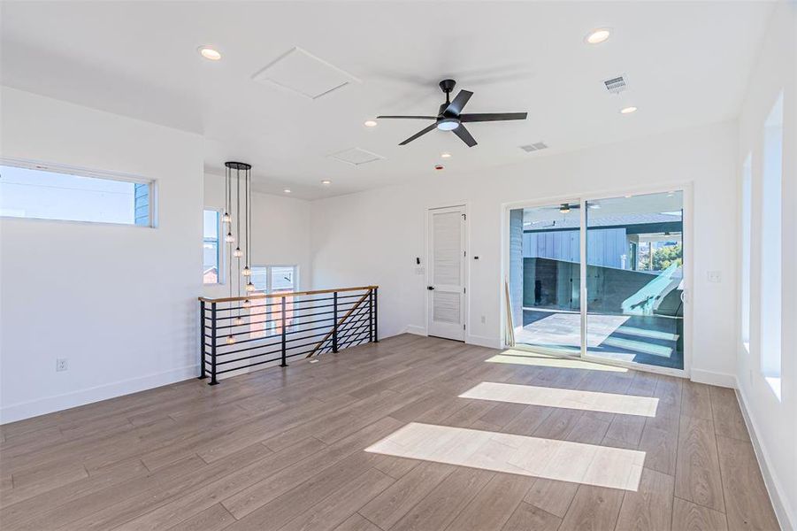 Spare room with healthy amount of natural light, light wood-style flooring, recessed lighting, and attic access