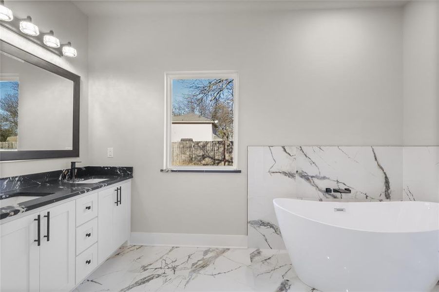 Bathroom featuring a tub to relax in and vanity