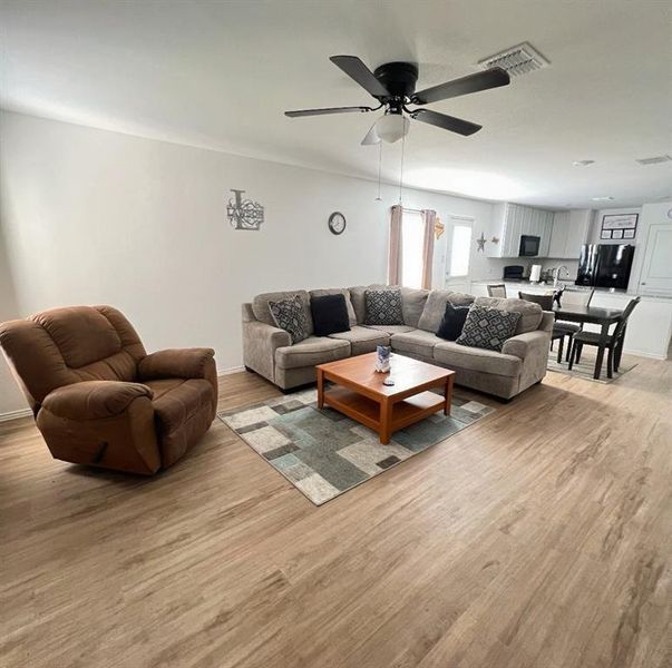 Living room featuring light wood-style flooring and ceiling fan Living room featuring light wood-style flooring and ceiling fan
