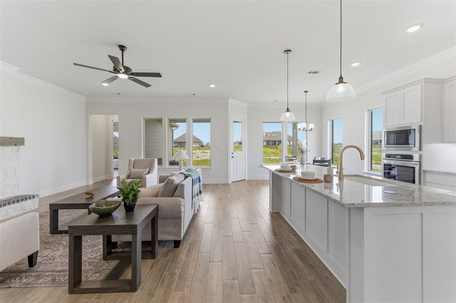 Open-concept living space with wood-finish flooring, recessed lighting, and a neutral color palette