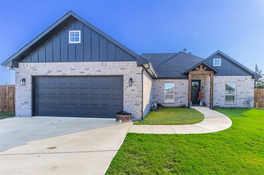 View of front of home featuring a garage and a front yard