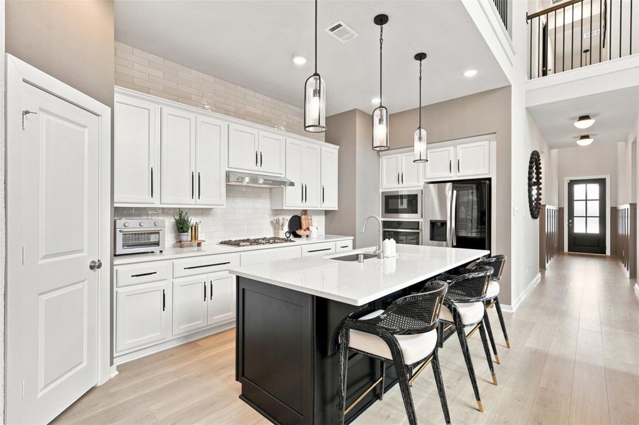 Oversized island with quartz countertops pull out trash can. Upgraded GE appliances and gas cook top. Walk-in pantry to your left. Ample amount of storage