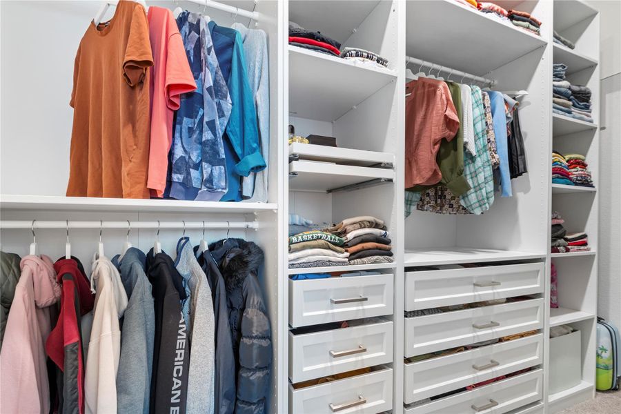 Custom built-ins and ample hanging space create an organized and highly functional closet system. Custom built-ins and ample hanging space create an organized and highly functional closet system.