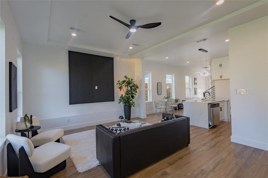 Living area featuring dark wood-style floors, recessed lighting, ceiling fan, and a tray ceiling Living area featuring dark wood-style floors, recessed lighting, ceiling fan, and a tray ceiling