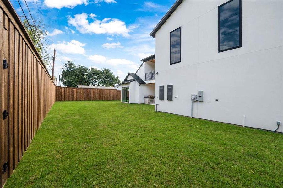 Fenced backyard with a balcony and a patio