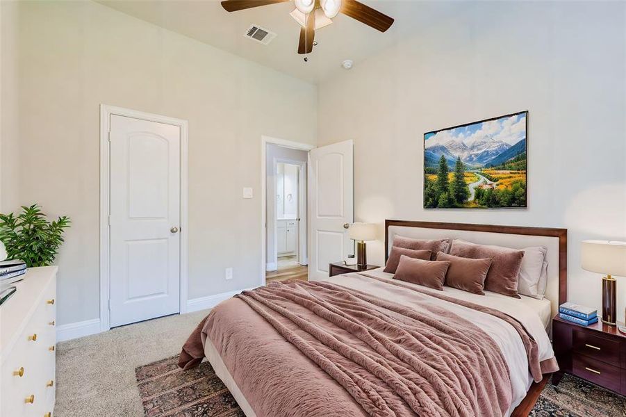 Carpeted bedroom featuring ceiling fan and a towering ceiling