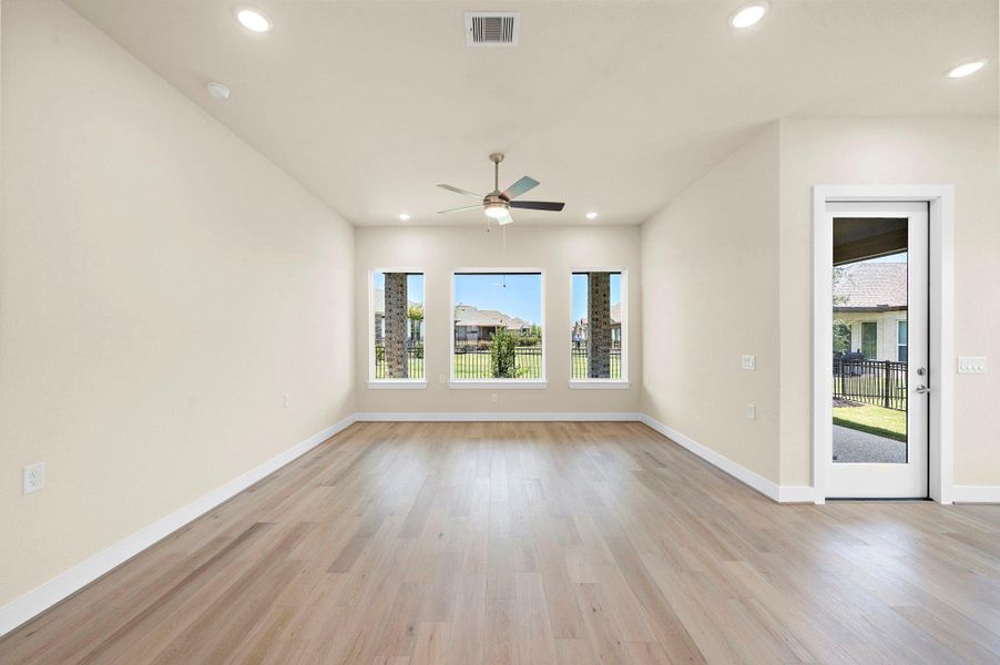 Spacious and sunlit living room with large windows showcasing greenbelt views and easy access to the covered patio — perfect for relaxing or entertaining in comfort. Spacious and sunlit living room with large windows showcasing greenbelt views and easy access to the covered patio — perfect for relaxing or entertaining in comfort.