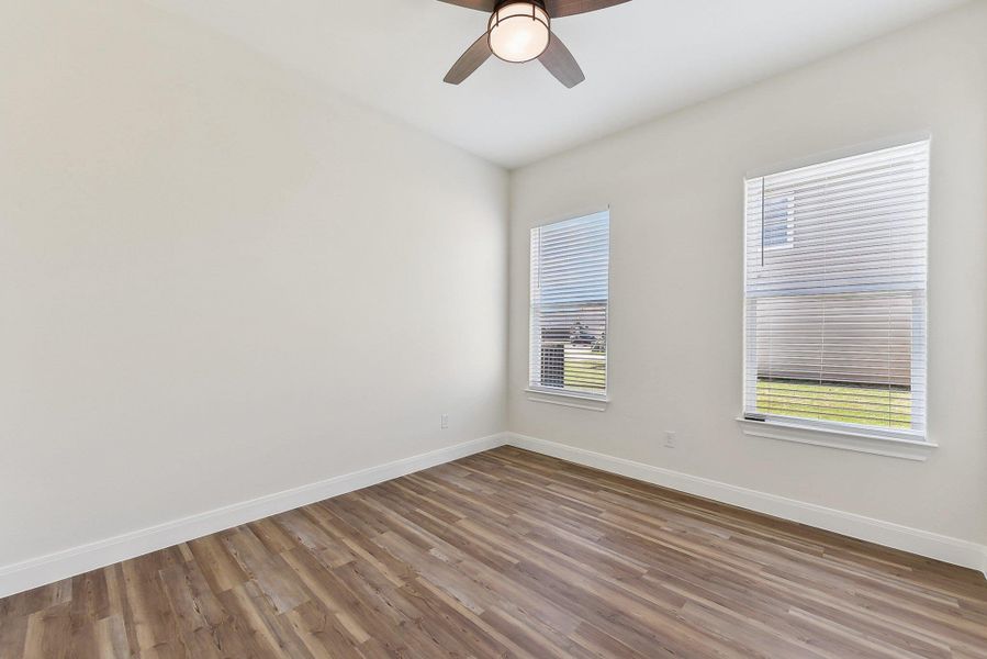 Bedroom 3 featuring a ceiling fan, baseboards, and wood finished floors Bedroom 3 featuring a ceiling fan, baseboards, and wood finished floors