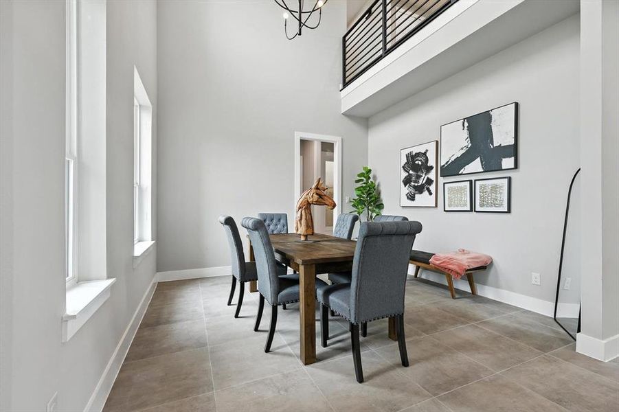 Dining area featuring a high ceiling, a chandelier, and concrete floors