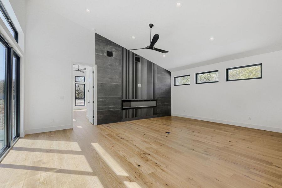 Unfurnished room with vaulted ceiling, light wood-type flooring, a ceiling fan, and recessed lighting Unfurnished room with vaulted ceiling, light wood-type flooring, a ceiling fan, and recessed lighting