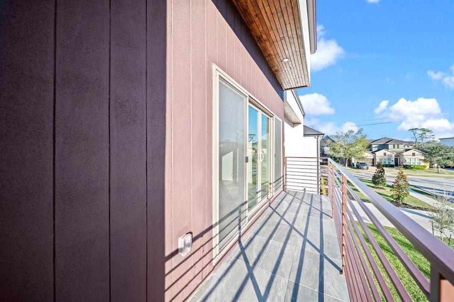 This private balcony offers a serene outdoor retreat with modern railing and sleek flooring, perfectly complementing the home's contemporary design. Enjoy picturesque views of the neighborhood, making this space ideal for morning coffee or evening relaxation. The covered wood-paneled ceiling adds an elegant touch, ensuring comfort and style for any occasion