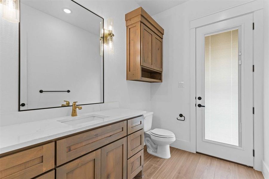 Bathroom featuring vanity, wood finish floors, and recessed lighting