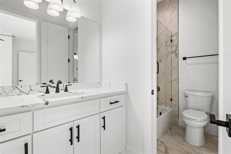 Bathroom featuring vanity, combined bath / shower with glass door, and light marble finish flooring Bathroom featuring vanity, combined bath / shower with glass door, and light marble finish flooring