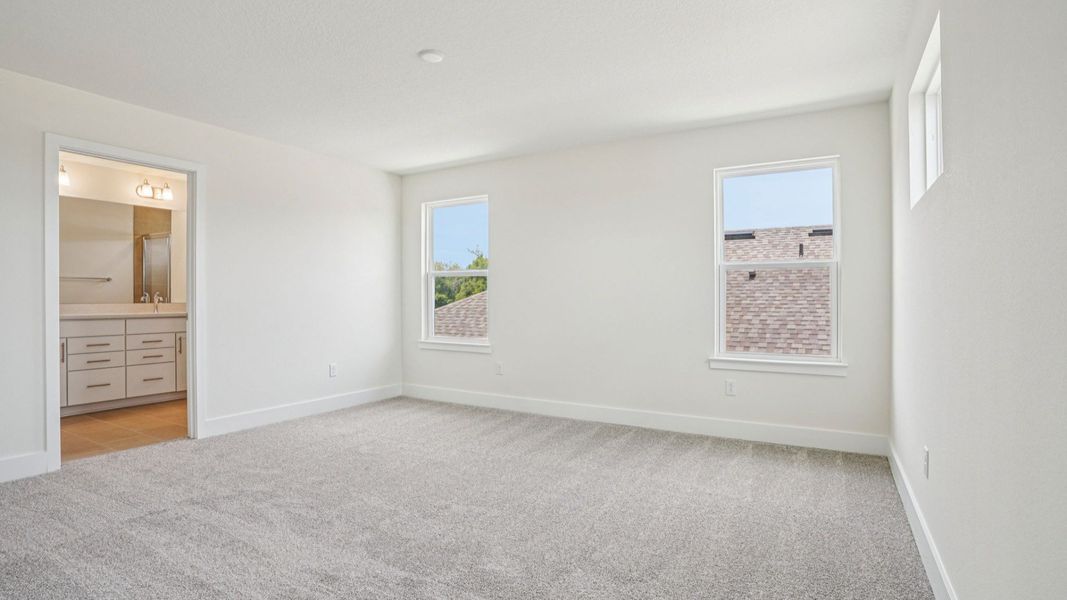 Spacious bedroom with windows in the Plumeria plan at Lakeside at Satilla by DRB Homes. Spacious bedroom with windows in the Plumeria plan at Lakeside at Satilla by DRB Homes.