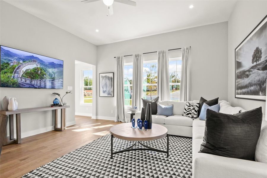 Living room featuring recessed lighting, wood finished floors, and a ceiling fan Living room featuring recessed lighting, wood finished floors, and a ceiling fan