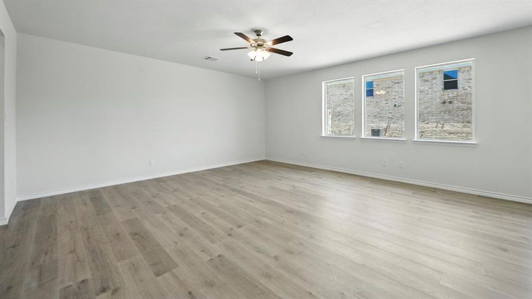 Empty room featuring light wood-style floors and a ceiling fan