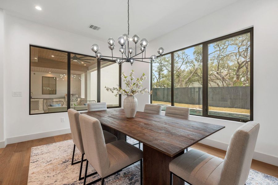 Dining space featuring suspended lighting and light wood-style flooring