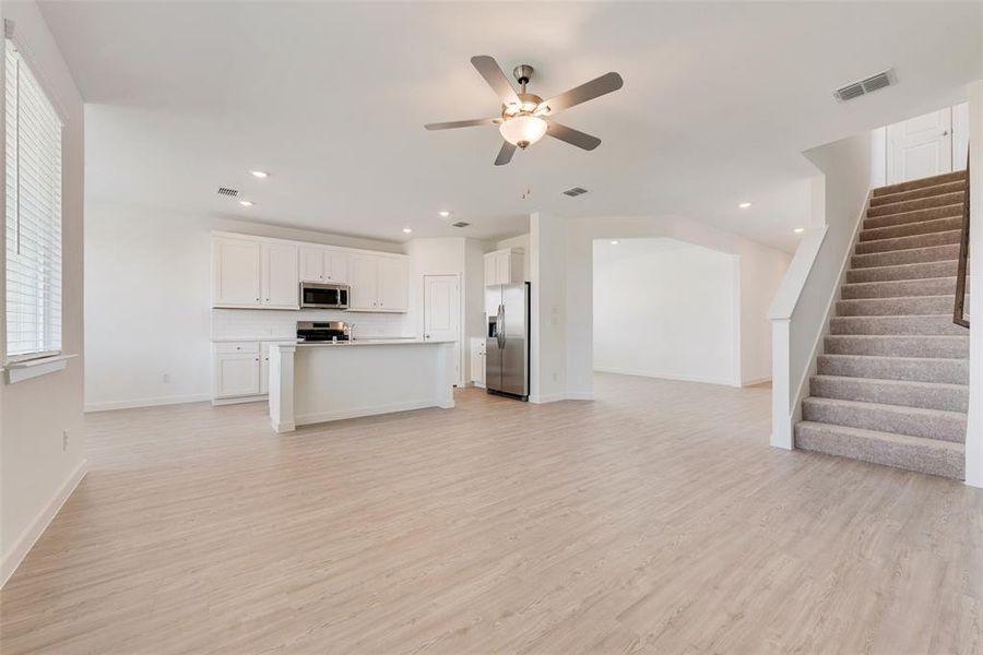 Unfurnished living room featuring light hardwood / wood-style flooring and ceiling fan