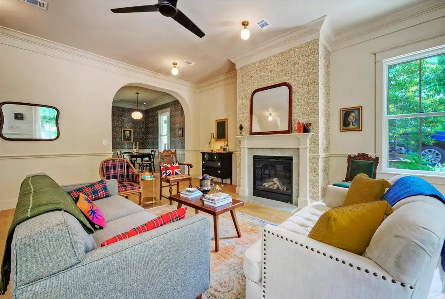 A refined living space showcasing a prominent fireplace and a seamless archway to an adjacent dining area.