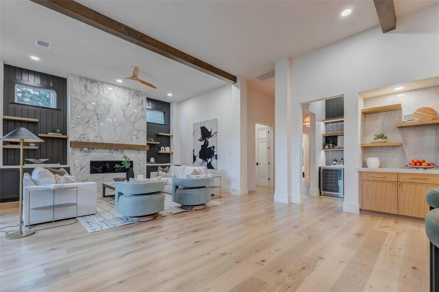 Another view of the open-concept living area reveals the home’s airy volume and light. Natural wood tones, modern cabinetry, and clean lines create a cohesive and inviting atmosphere from kitchen to family room.