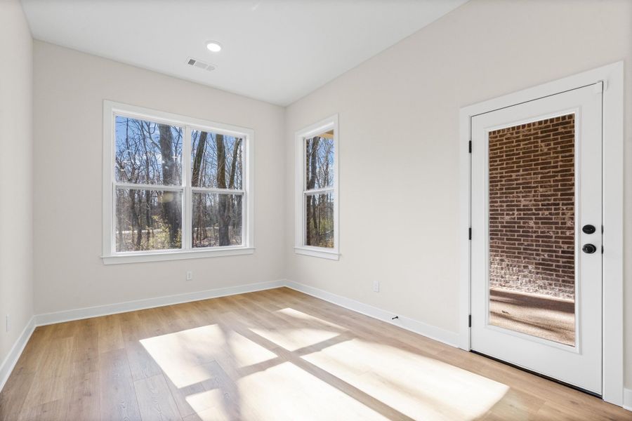 Empty room featuring light wood-style flooring and plenty of natural light Empty room featuring light wood-style flooring and plenty of natural light
