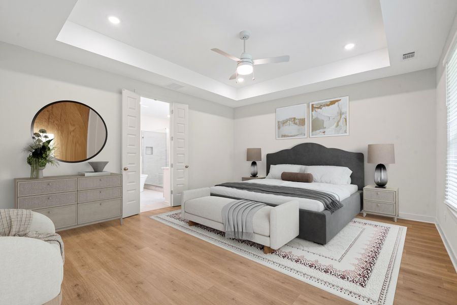 Bedroom with wood-finish flooring, tray ceiling, recessed lighting, and a ceiling fan Bedroom with wood-finish flooring, tray ceiling, recessed lighting, and a ceiling fan