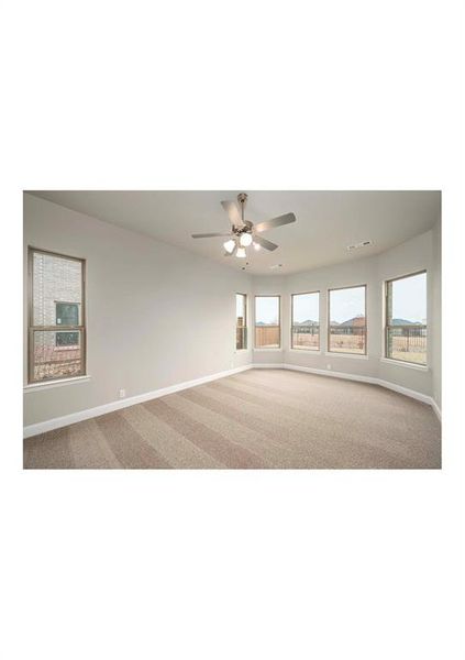 Carpeted empty room featuring ceiling fan