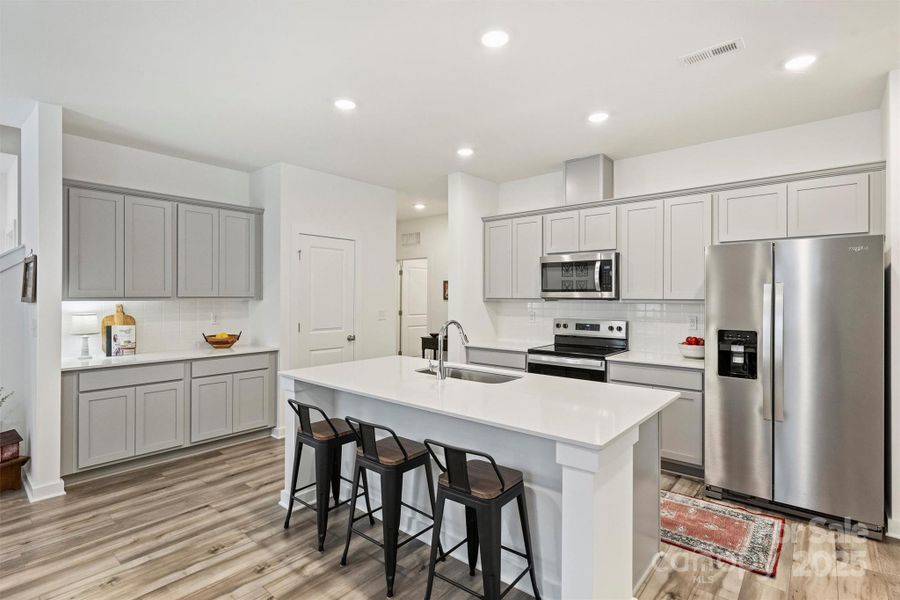 Loads of subtle gray cabinetry provide ample storage for all of your needs.