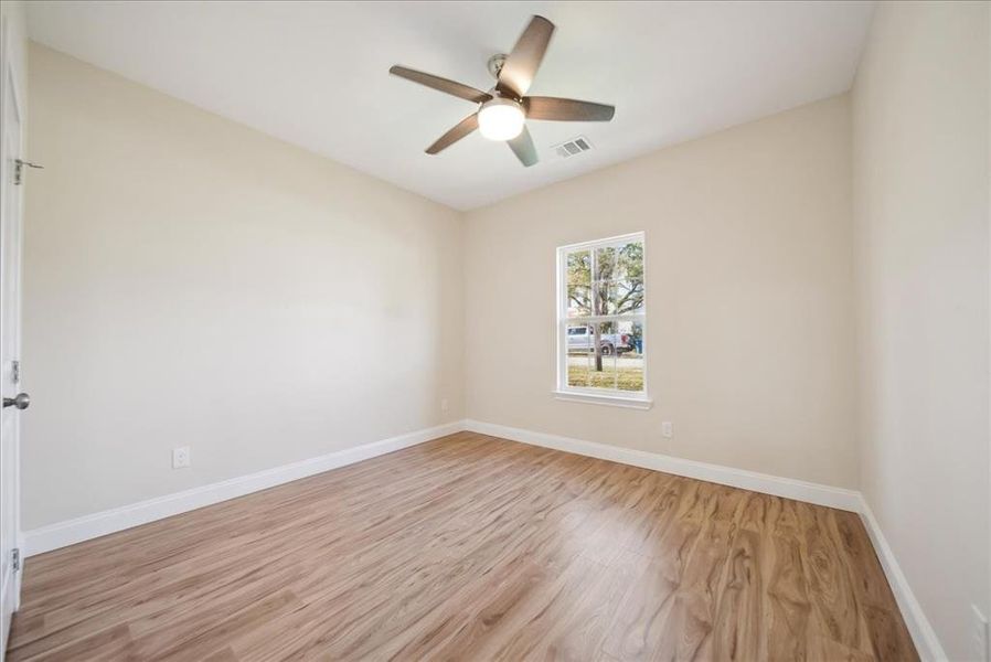 Unfurnished room featuring ceiling fan and light wood-type flooring