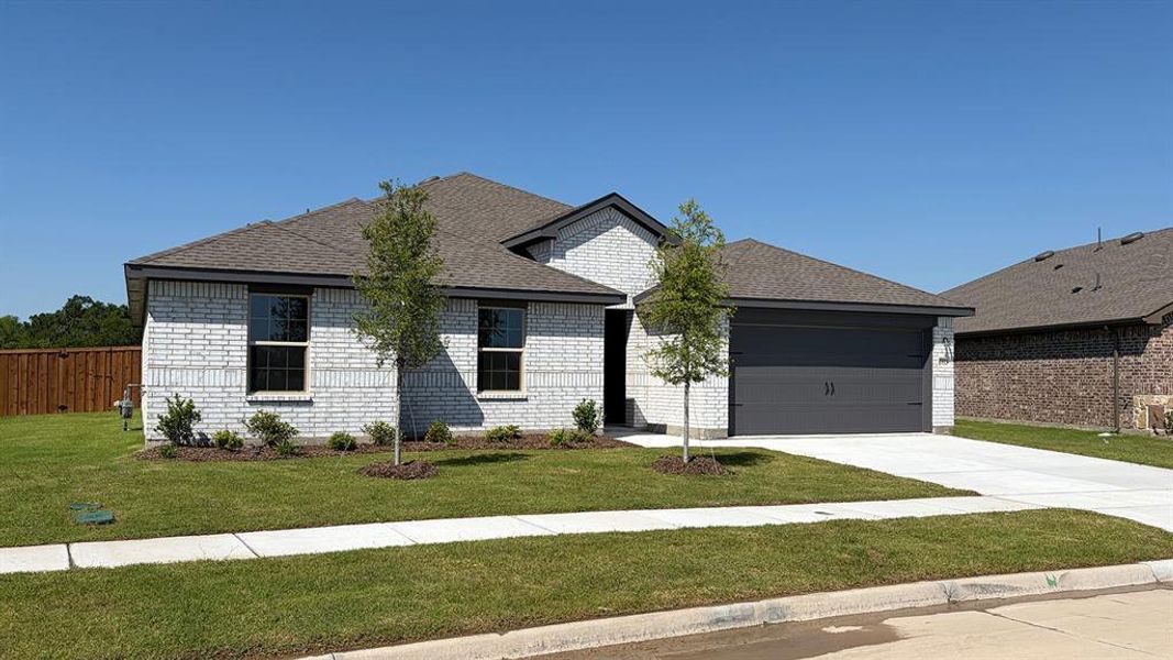 Single-story residence featuring light-colored brick veneer, a dark asphalt shingle roof, and a two-car garage with a dark gray door Single-story residence featuring light-colored brick veneer, a dark asphalt shingle roof, and a two-car garage with a dark gray door