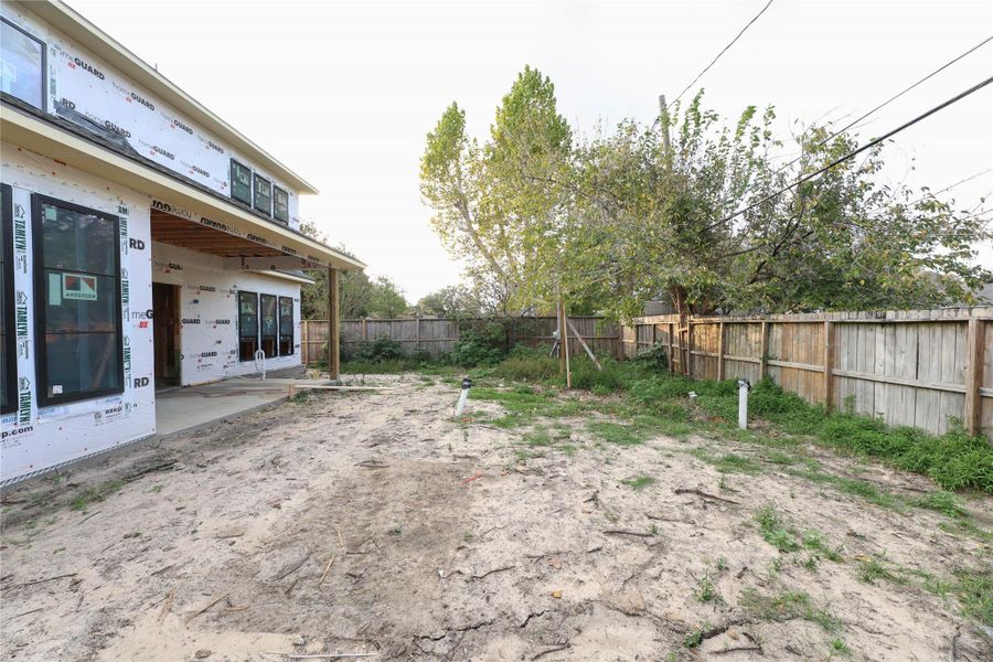 Back yard side view shows the depth and breadth of the yard. Back yard is large enough for pool and green space. New fencing will be installed all around. *Pool is not included with home*