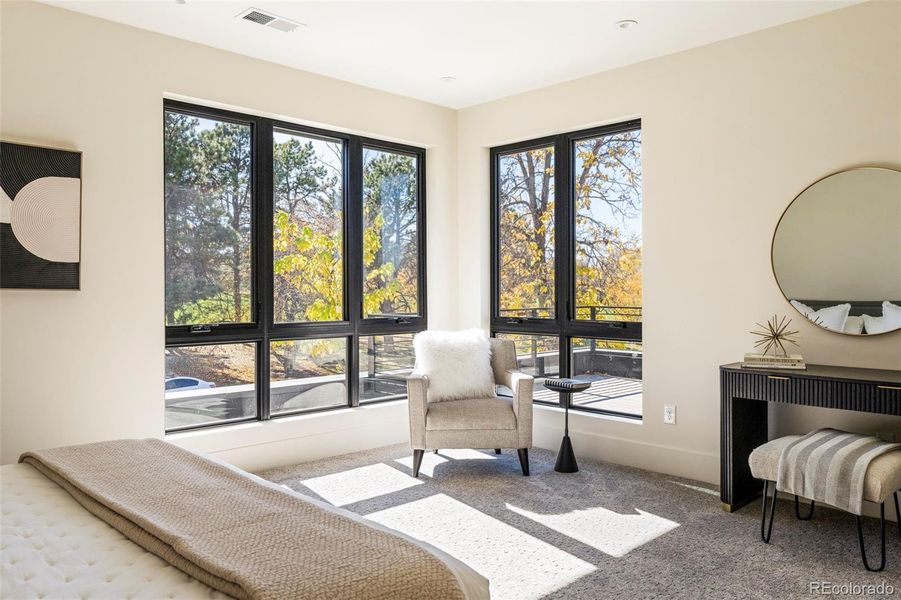 Corner primary suite overlooking the lush greenery