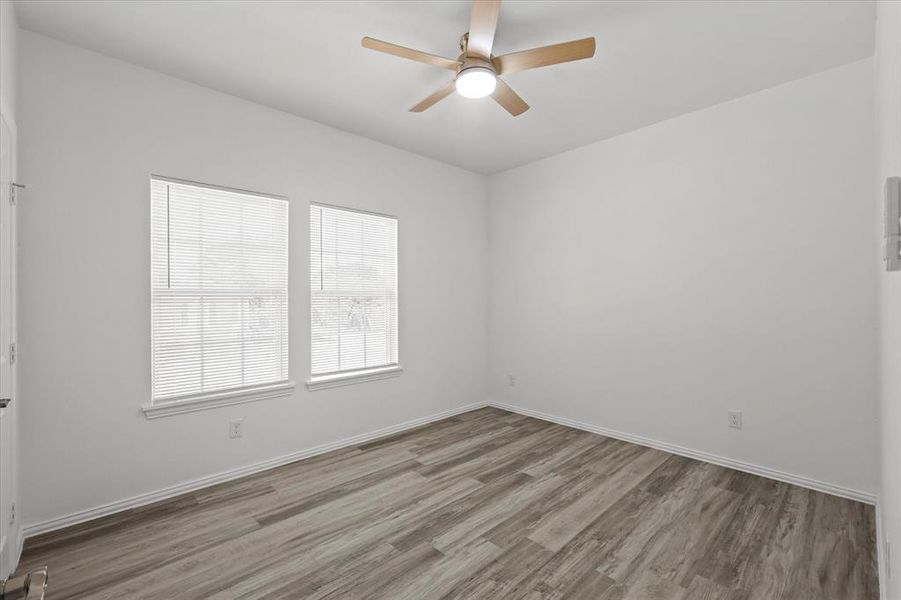 Unfurnished room featuring a ceiling fan, wood finished floors, and baseboards