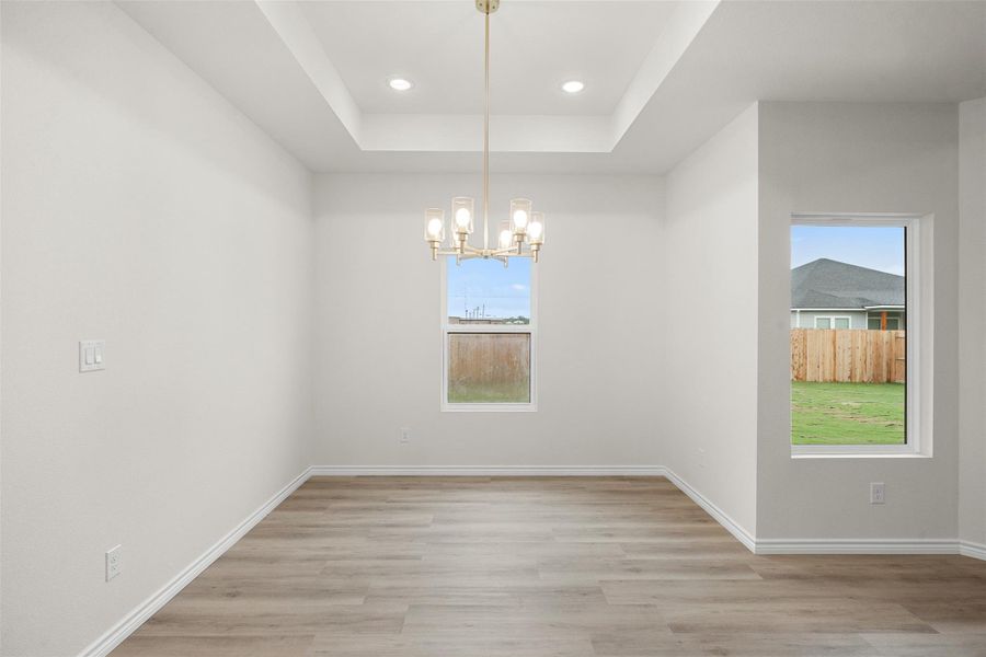 A tray ceiling with recessed lighting enhances this versatile dining area. A tray ceiling with recessed lighting enhances this versatile dining area.