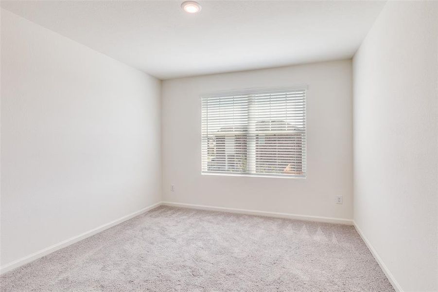 Empty room featuring light carpet and baseboards