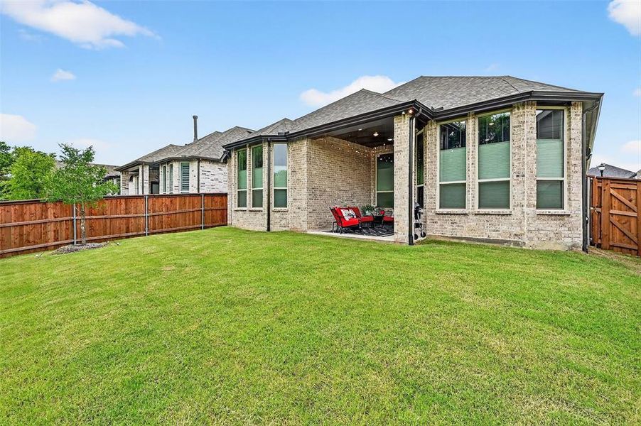 Back of house featuring a fenced backyard, a patio, brick siding, and roof with shingles Back of house featuring a fenced backyard, a patio, brick siding, and roof with shingles