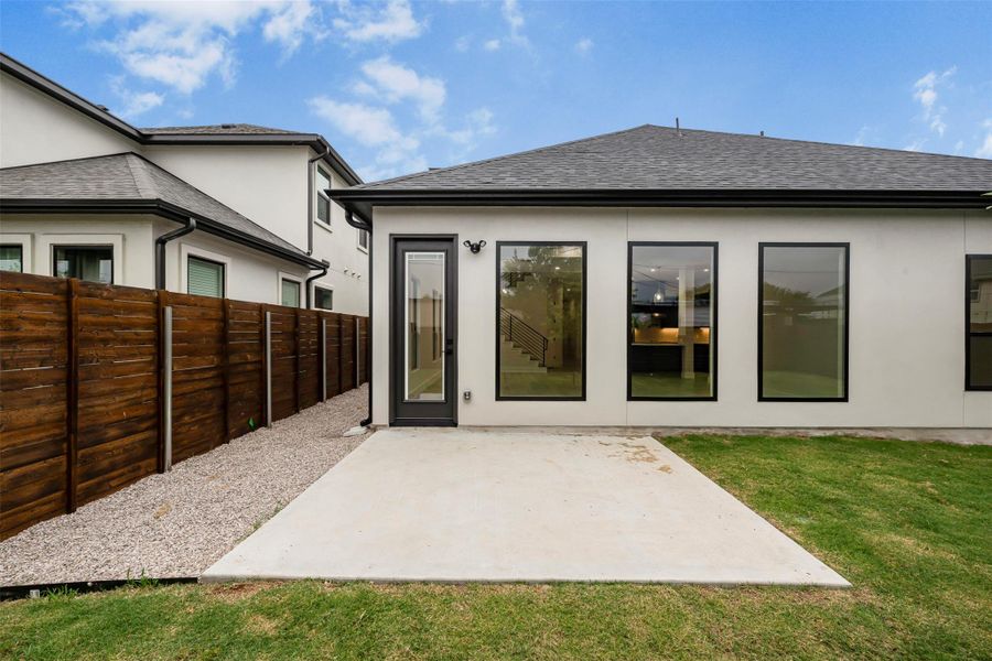Rear view of property featuring a patio, stucco siding, and shingled roof. Rear view of property featuring a patio, stucco siding, and shingled roof.