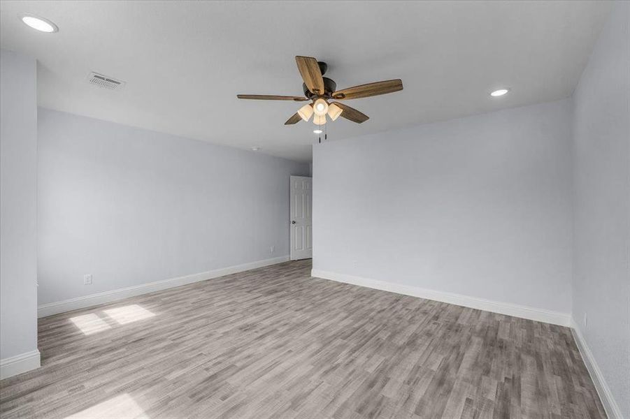 Empty room featuring light wood-style floors, a ceiling fan, and recessed lighting
