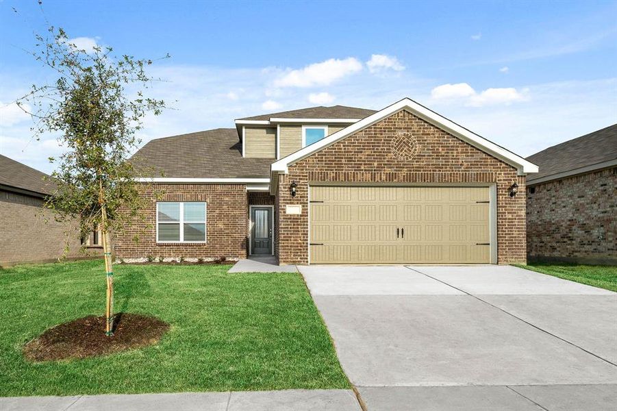 View of front of property featuring a front yard and a garage