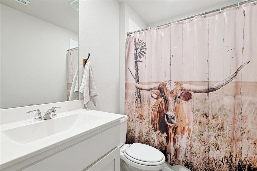 Bathroom featuring visible vents, vanity, and toilet
