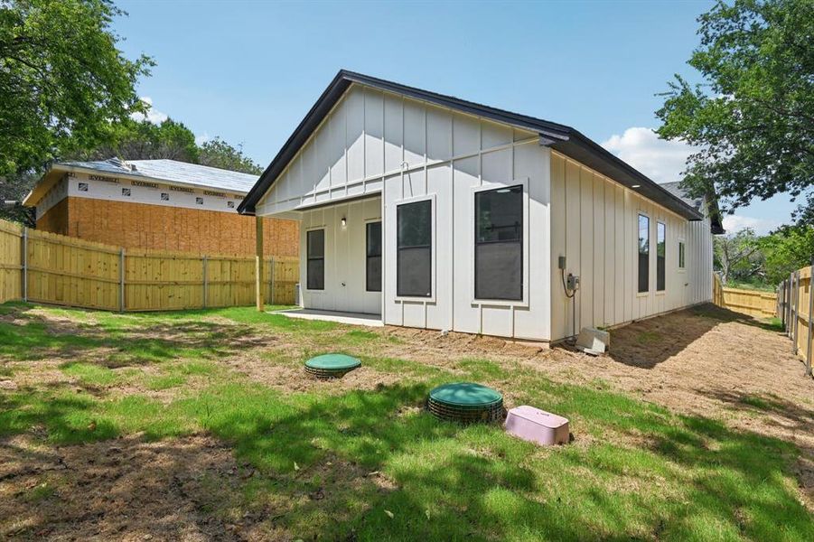 Rear view of property with board and batten siding and a fenced backyard Rear view of property with board and batten siding and a fenced backyard