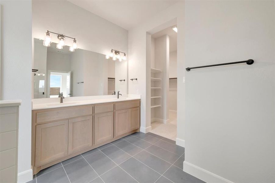 Double vanity with wood-finish cabinetry, white countertops, and dual vessel sinks
