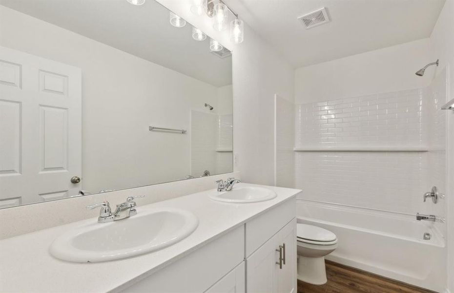 Elegant owner's bathroom with dual vanity *real home pictured