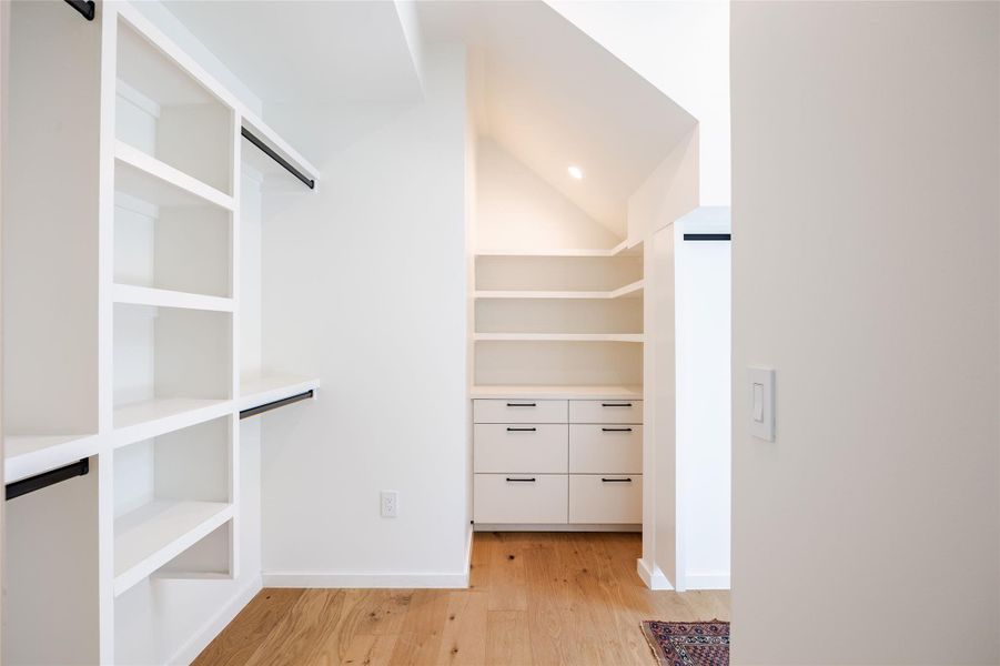 Spacious closet featuring light wood-type flooring and vaulted ceiling