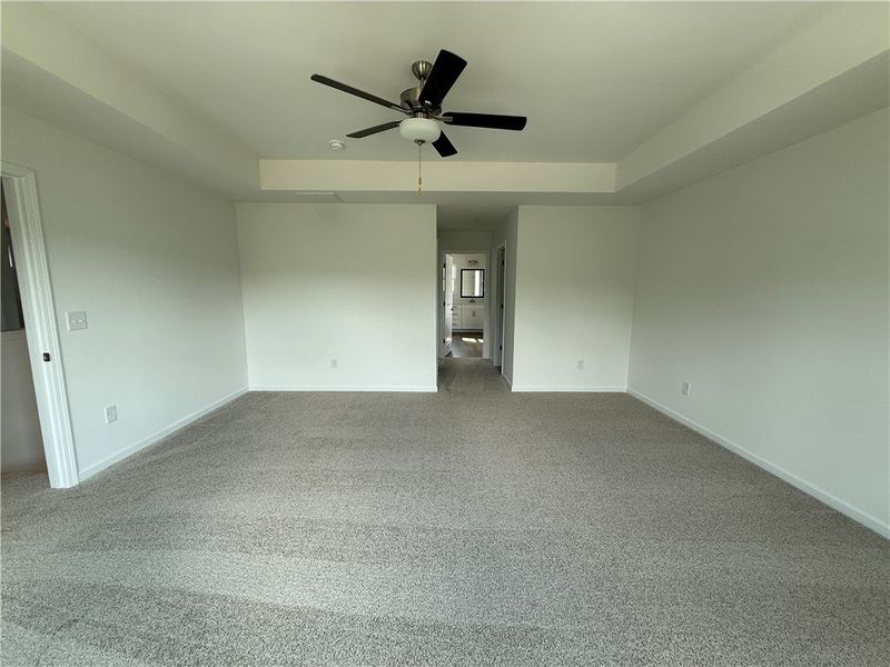 A spacious primary bedroom features soft carpeting A spacious primary bedroom features soft carpeting