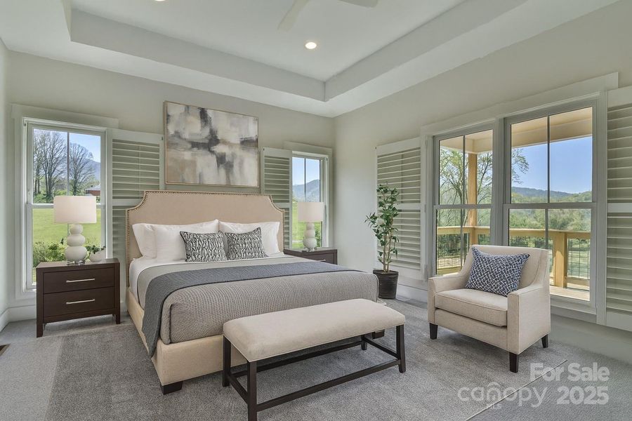 Primary bedroom with tray ceiling and lots of windows. Virtually staged.