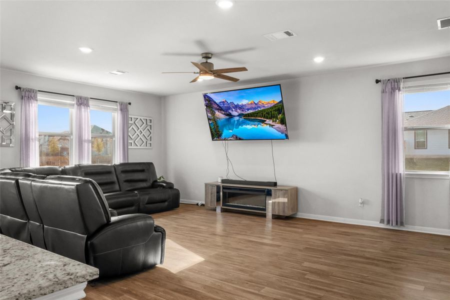 Living area featuring ceiling fan, wood finished floors, healthy amount of natural light, and recessed lighting
