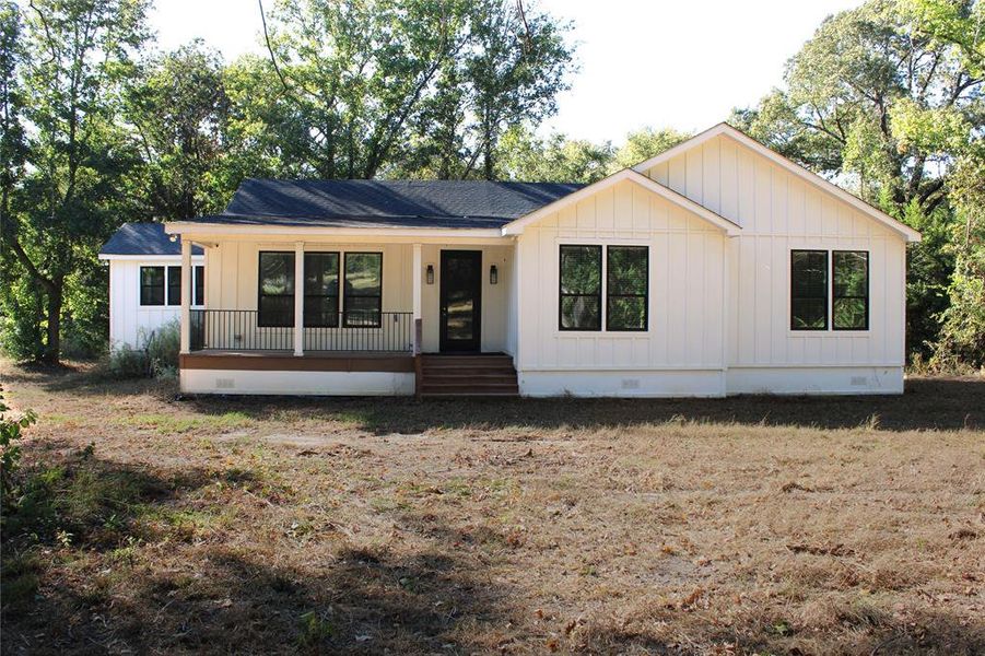 Modern farmhouse featuring crawl space, covered porch, board and batten siding, and roof with shingles