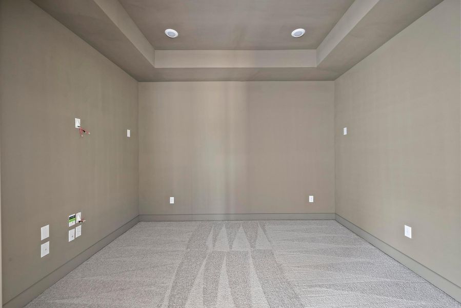 Unfurnished room featuring carpet flooring, a tray ceiling, and baseboards Unfurnished room featuring carpet flooring, a tray ceiling, and baseboards